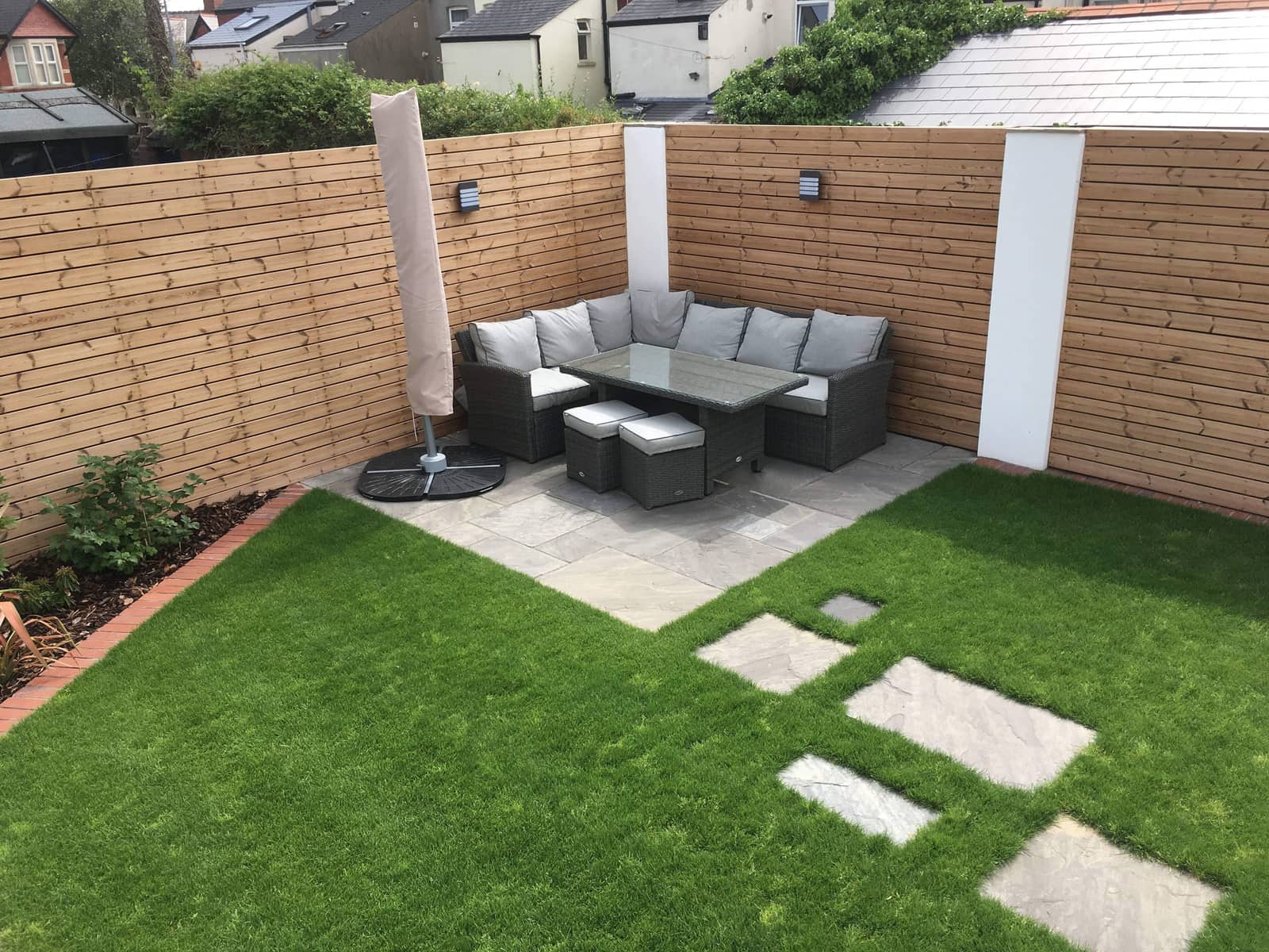 The Amesbury Road garden — porcelain terrace, level lawn and timber-clad walls.