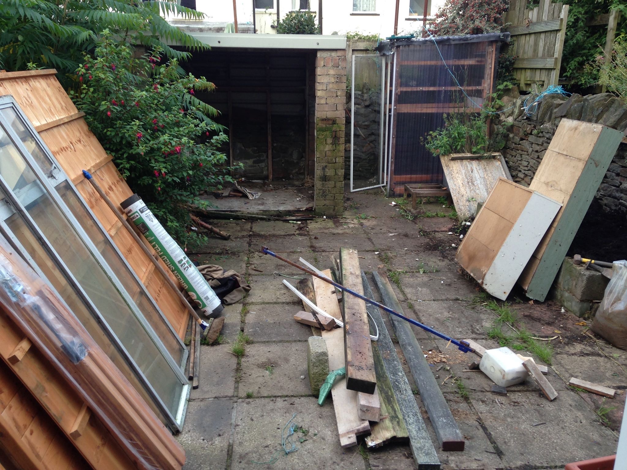 Before: cluttered back yard with old shed and timber waste